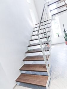 Walnut-stained beech zig zag staircase with white steel strings