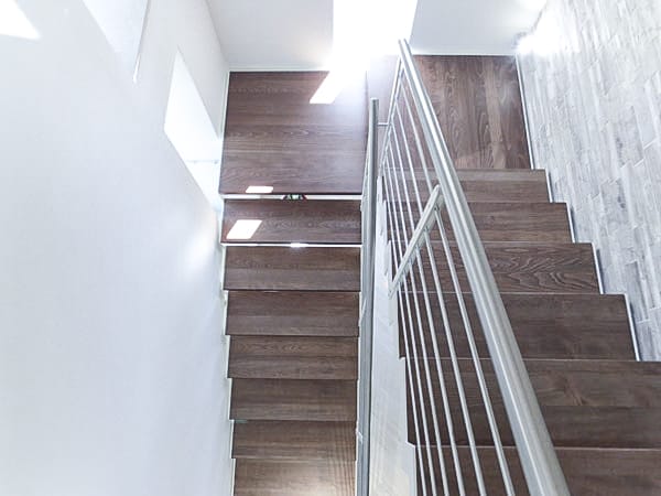 Walnut-stained beech zig zag staircase with white steel strings