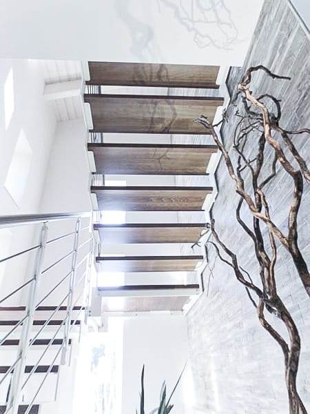 Walnut-stained beech zig zag staircase with white steel strings